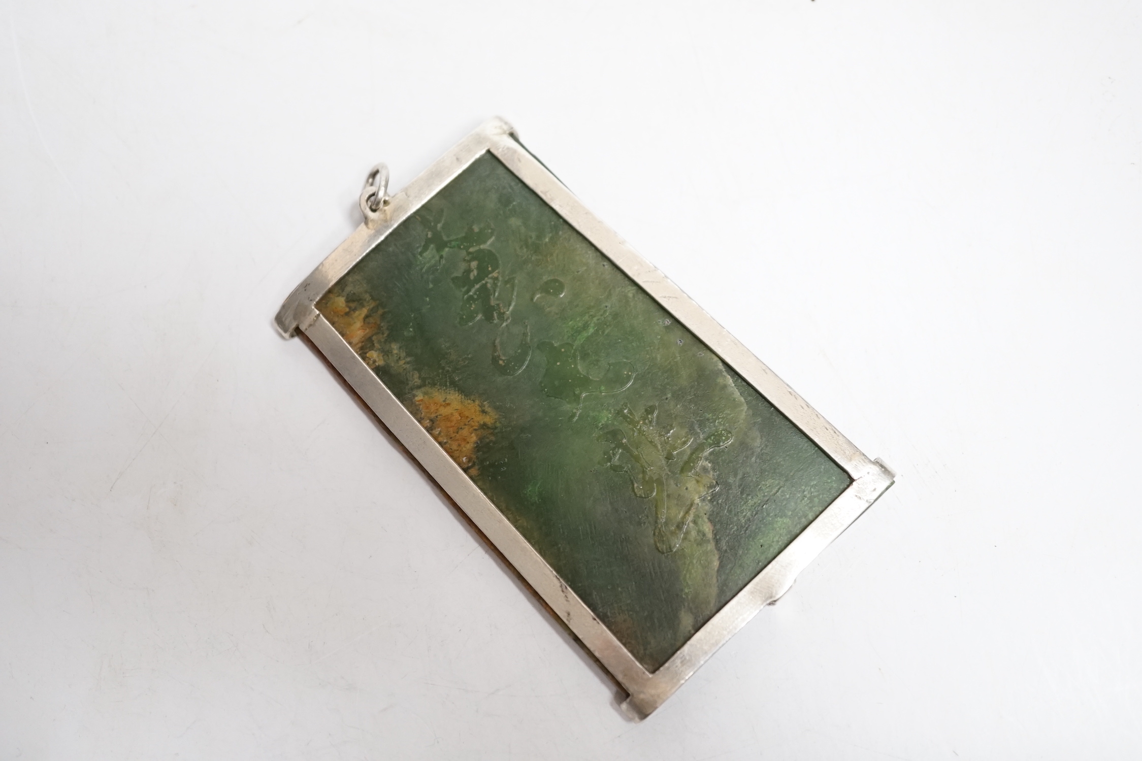 A Chinese carved spinach green jade panel, 9cms high.